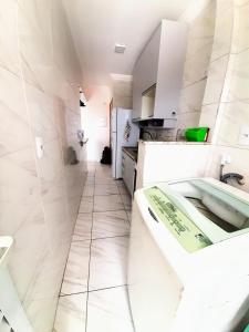 大普拉亚Apartamento Mirim Praia Grande的白色的浴室设有浴缸和水槽。