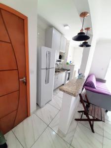 大普拉亚Apartamento Mirim Praia Grande的厨房配有白色冰箱和桌子