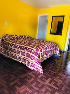 奥克兰海军准将汽车旅馆的一间卧室设有一张床和黄色的墙壁