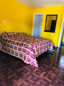 奥克兰海军准将汽车旅馆的一间卧室设有一张床和黄色的墙壁