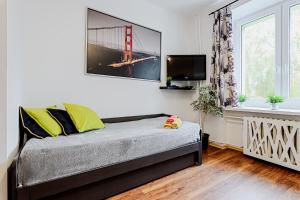 罗兹deLux1的一间卧室配有一张床,墙上配有电视