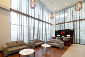 蒙特雷Holiday Inn & Suites - Monterrey Apodaca Zona Airport, an IHG Hotel的带沙发和桌子的客厅以及大窗户。