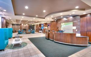 盐湖城Holiday Inn & Suites Salt Lake City - Airport West, an IHG Hotel的酒店大堂设有前台和蓝色椅子