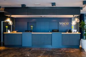 菲拉赫voco® Villach, an IHG Hotel的一间房间里带凹形柜台的蓝色墙壁