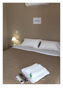 圣萨尔瓦多德朱Caminos Hostal的一间卧室配有带两个遥控器的床