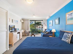 黄金海岸Calypso Plaza Resort Unit 215的蓝色的卧室配有床和沙发