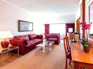 卡那斯卢森堡菊冈美居高尔夫及Spa酒店的客厅配有沙发和桌子