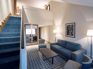 卡那斯卢森堡菊冈美居高尔夫及Spa酒店的带沙发和楼梯的客厅