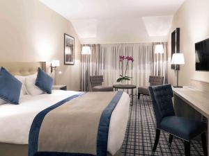 卡那斯卢森堡菊冈美居高尔夫及Spa酒店的酒店客房带一张床、一张桌子和椅子