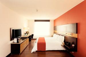波哥大美居波哥大Bh雷蒂罗酒店的酒店客房,配有床和电视