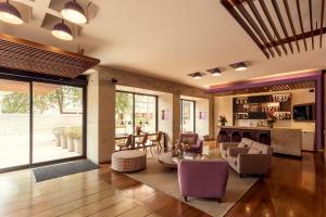 波哥大美居波哥大Bh雷蒂罗酒店的客厅配有紫色椅子和桌子