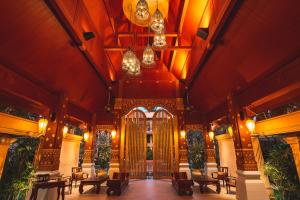 芭东海滩Burasari Phuket Resort & Spa的一座华丽的建筑,设有大门和桌椅