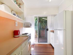 黄金海岸Tondio Terrace Flat 3 - Pet Friendly and close to the beach的厨房配有白色橱柜和冰箱。
