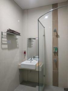 泗水Choice City Hotel的一间带水槽和玻璃淋浴的浴室