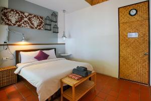 蒙诺克岛Koh Munnork Private Island的卧室配有一张床和一张桌子,墙上挂着一个时钟