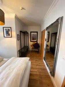库阿肯布吕克Hotel Hagspihl的一间带镜子和床的卧室以及一间客厅
