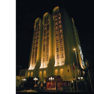 迪拜Al Khaleej Palace Deira Hotel的一座在晚上有灯的大建筑