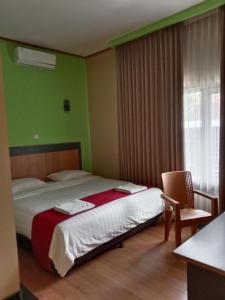 Wonosari纽奥尔琳德斯旅馆的卧室配有床、椅子和窗户。