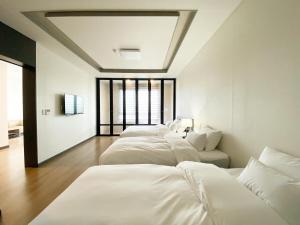 蔚山Hotel Daoom的房间里的一排白色的床