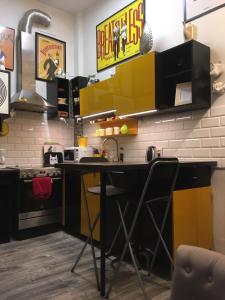托伦Pod Witrażem的厨房配有黄色和黑色橱柜和柜台
