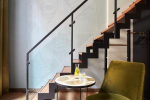 海牙海牙英迪格酒店 - 努儿登堡宫的楼梯旁边的桌子和椅子