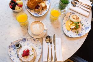 海牙海牙英迪格酒店 - 努儿登堡宫的餐桌,带早餐盘和橙汁