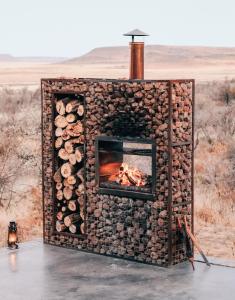 LuckhoffEco Karoo Mountain Lodge的壁炉,壁炉用木头制成