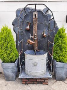 ColdwalthamThe Labouring Man的金属结构中的水喷泉,有两座植物
