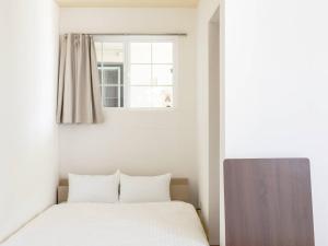 富士河口湖Bluebird Hotel的一间卧室设有一张床和一个窗口
