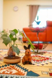 北冲班如布罗摩拜简公寓的一张桌子上放着兔子和两株盆栽植物