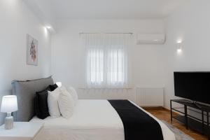 雅典Kolonaki Luxury Residence的白色卧室配有床和平面电视
