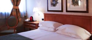 普雷甘纳·米拉内斯莫妮卡费奥拉酒店的一间卧室配有一张带木制床头板的床和一张书桌