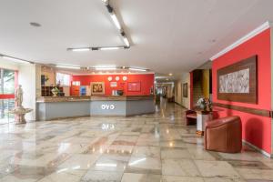 贝洛奥里藏特OYO Hotel L'Espace - Jaraguá Belo Horizonte的医院的大厅,有红墙