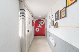 圣保罗OYO Hotel San Remo, São Paulo的走廊上,房间里有一个红色的门