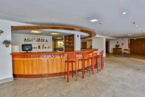 巴西利亚Flat Plaza Hotel - Setor de Hotéis Norte的大房间中带红色凳子的酒吧