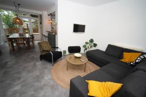 贝克Vakantiehuis Le Platane - in natuurgebied nabij Nijmegen的客厅配有黑色沙发和桌子