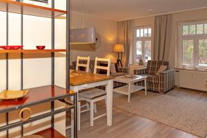 奥斯赛拜-屈隆斯博恩Residenz-Ostseewind-Wohnung-7-9618的厨房以及带桌椅的起居室。