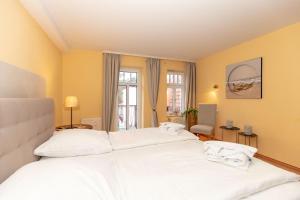 奥斯赛拜-屈隆斯博恩Residenz-Ostseewind-Wohnung-7-9618的一间卧室设有两张白色的床和窗户