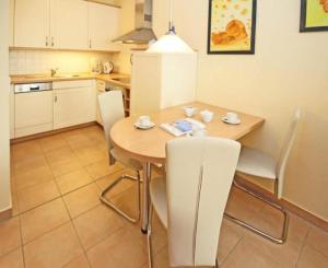 奥斯赛拜-屈隆斯博恩Residenz-Ostseestrand-Wohnung-4-9624的厨房配有桌椅
