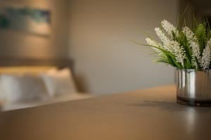 维拉卡洛斯帕兹Eleton Resort & Spa的花瓶,花瓶上满是白色的花朵,坐在桌子上