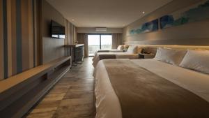 维拉卡洛斯帕兹Eleton Resort & Spa的酒店客房设有两张床和电视。