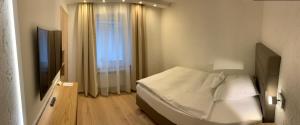 门兴格拉德巴赫林德霍夫酒店的一间白色卧室,配有床和电视
