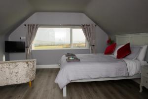 波特马吉Atlantic Sunset的一间卧室配有一张带红色枕头的床和一扇窗户