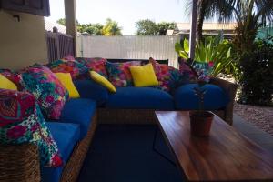 卡宴LA KAZ KRÉOL的一张带色彩缤纷的枕头的蓝色沙发和一张木桌
