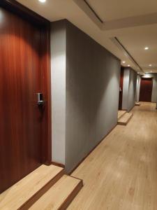 斯里巴加湾市EZ Suites的办公室走廊,设有木门和木地板