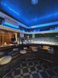 塞维利亚Hostal Avenida Andalucia的酒吧里设有凳子,酒吧里设有蓝色的灯光