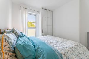 卡西斯Le Grand Large par Dodo à Cassis的一间卧室配有一张带蓝色床单的床和一扇窗户。