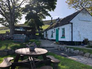 纽里Carrick Lodge Mourne Mountains的白色建筑前的野餐桌