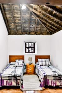 GarafíaCASA VILA的卧室设有两张床铺和木制天花板
