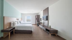比亚埃尔莫萨Staybridge Suites - Villahermosa Tabasco, an IHG Hotel的酒店客房,配有床和电视
